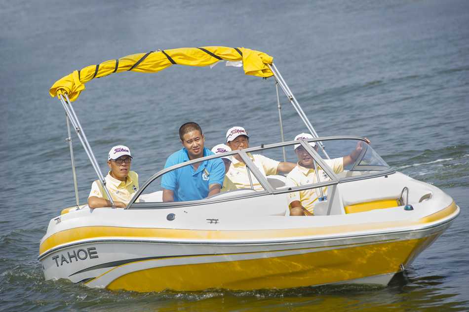 一位球员站在码头栈桥，迎着湖风优雅挥杆，小白球划出优美弧线，飞向波光粼粼的湖心方向。