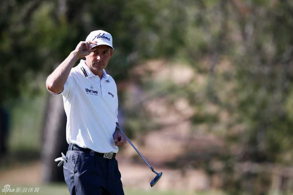 赛事领先组球员们依次走上开阔的发球台，阳光洒在修剪整齐的球道和远处的树林上，构成一幅宁静而充满张力的赛场画卷。