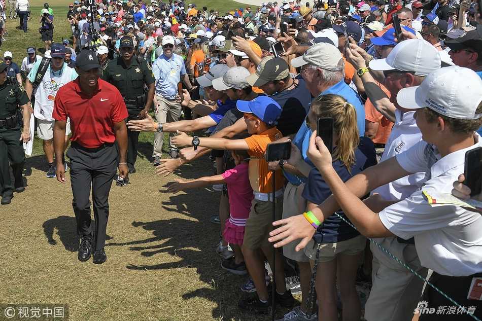 老虎伍兹在赛后走向围绳边，微笑着与热情的球迷们击掌互动，将帽檐下的笑容留给支持他的人们。