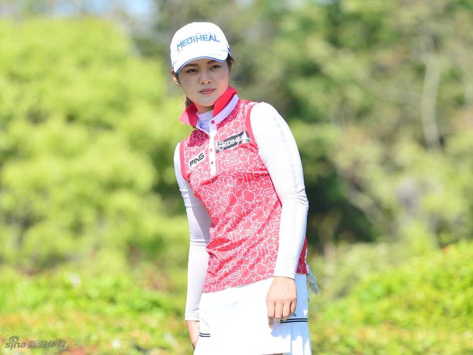 冠军福山惠梨在练习果岭上露出自信的微笑，手中的推杆稳稳对准目标，彰显卫冕者的从容气度。