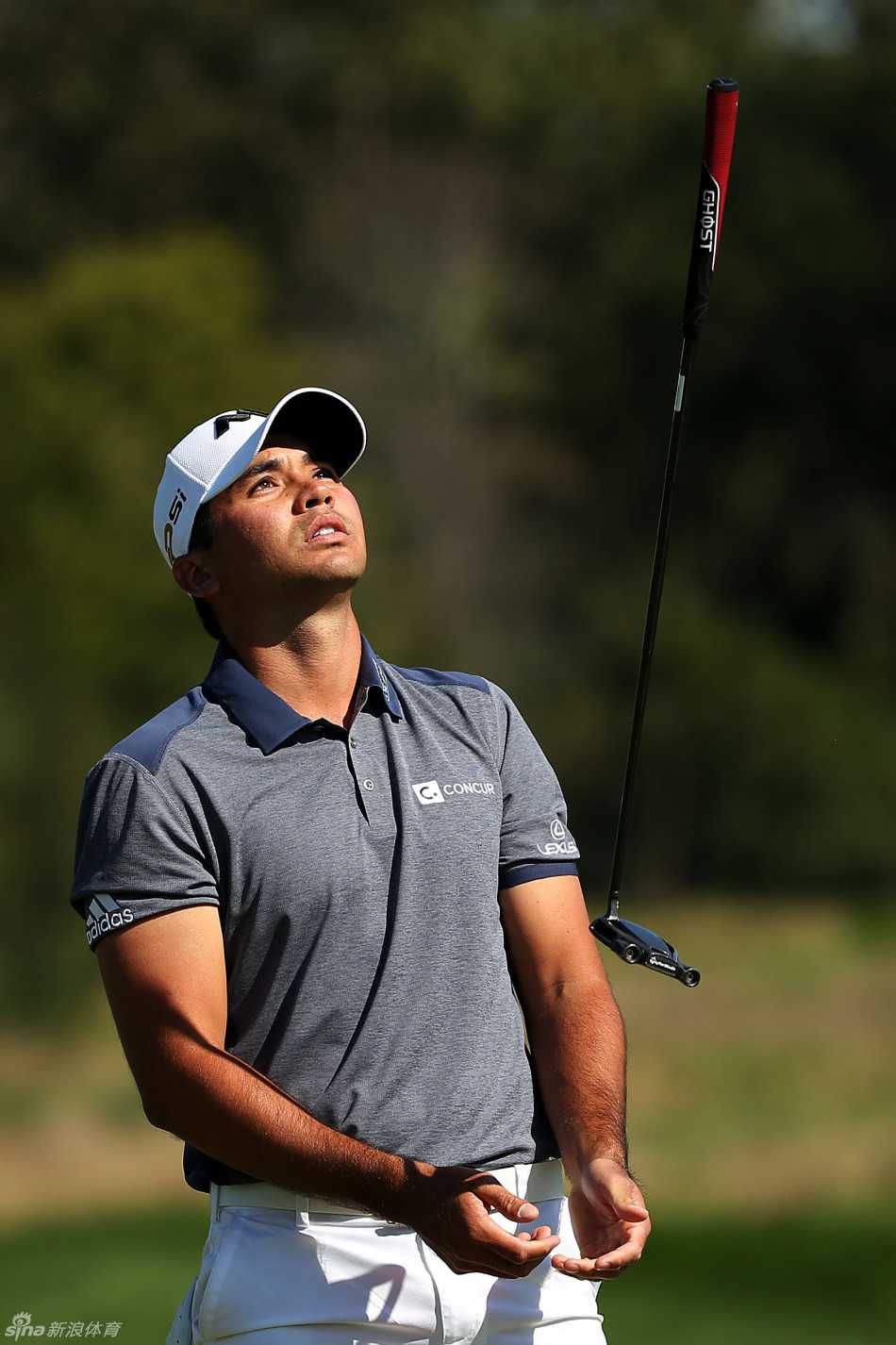 戴伊在果岭上俯身观察推杆线路，神情专注，冠军气质显露无遗。