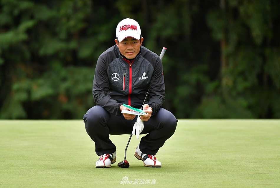 梁文冲在果岭上果断推出小球，目光坚定地跟随球的轨迹，充满对进洞的期待与自信。