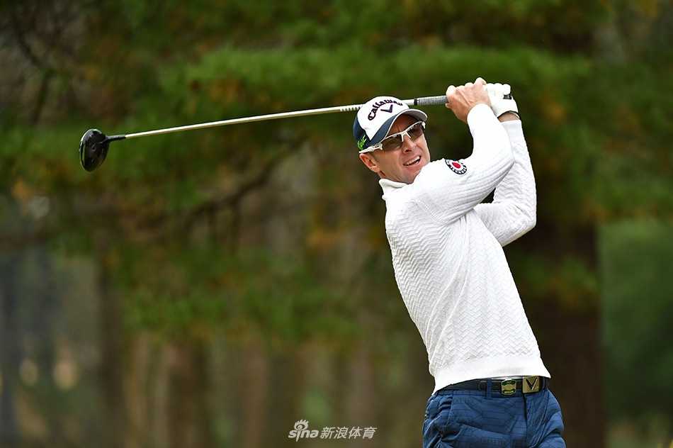 梁文冲在完成一次漂亮的击球后顺势收杆，动作流畅而完整，目光望向小球飞往的目标方向。