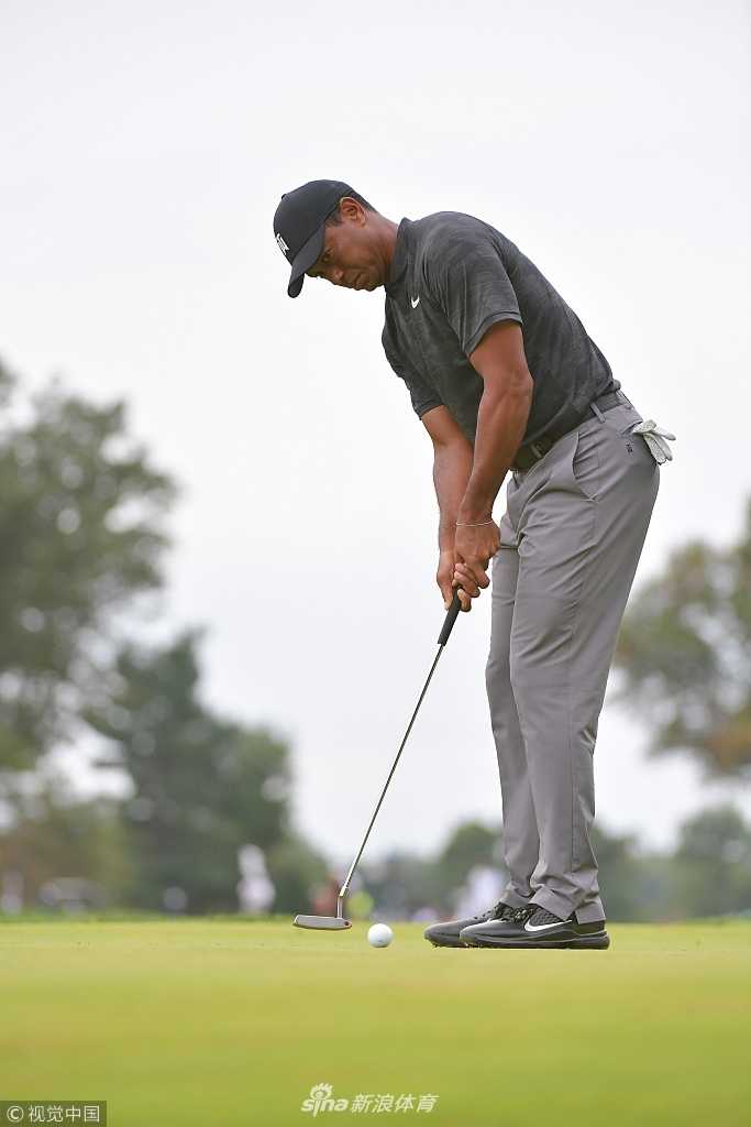 伍兹凝神准备推击，帽檐下目光如炬，手中推杆稳如磐石