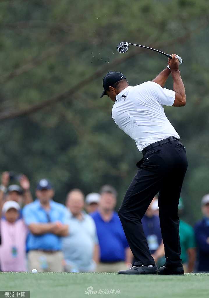 伍兹在练习轮中露出少见的轻松笑容，与严峻的复出背景形成对比，展现了瞬间的愉悦。