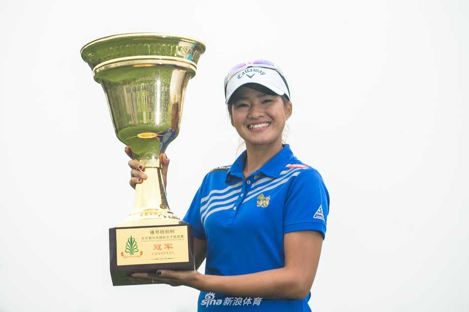 泰国冠军热努卡优雅挥杆，白色上衣在翠绿球场的映衬下显得格外瞩目