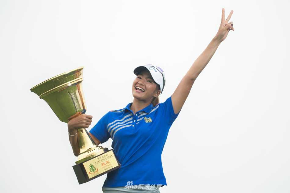 中国球员石昱婷在树林掩映的球道中帅气挥杆，动作流畅充满力量