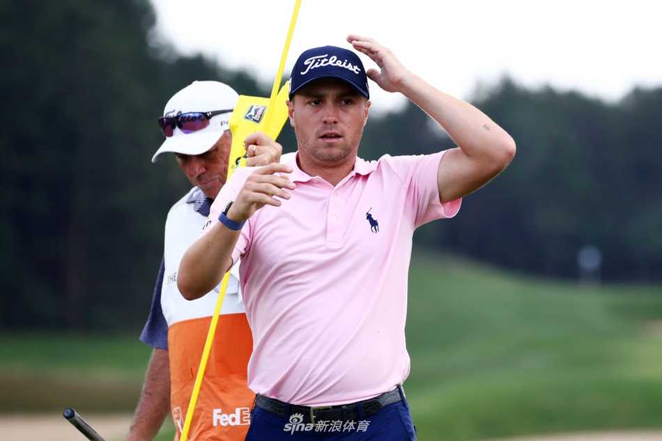 托马斯与赛事工作人员及嘉宾一同在领奖台上合影，高举奖杯庆祝胜利，现场彩带飘舞，气氛热烈。