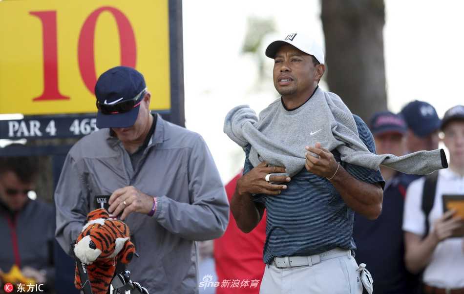 伍兹在卡诺斯蒂著名的壶状沙坑中屏息凝神，正练习高难度的沙坑救球，沙粒在他的杆头下划出一道精准的弧线。