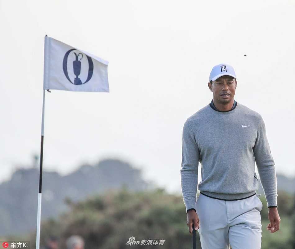 老虎伍兹身着驼色毛背心与白色紧身长袖衫，在卡诺斯蒂的寒风中专注地进行推杆练习，眼神坚定如昔。