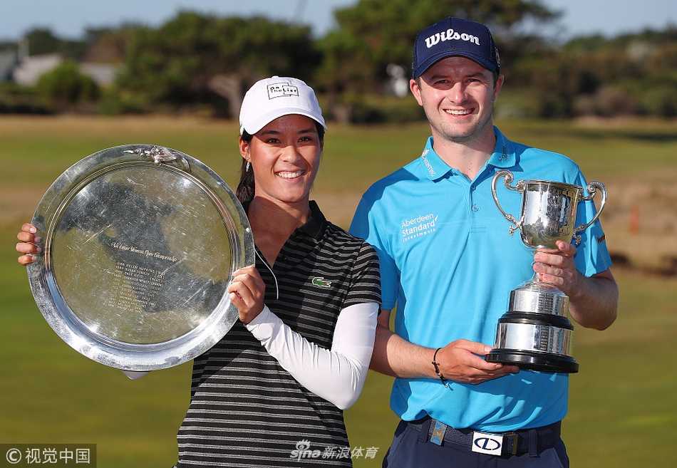 大卫·劳在第十八洞果岭高举奖杯，笑容灿烂，背后是夕阳映照下的金色海岸