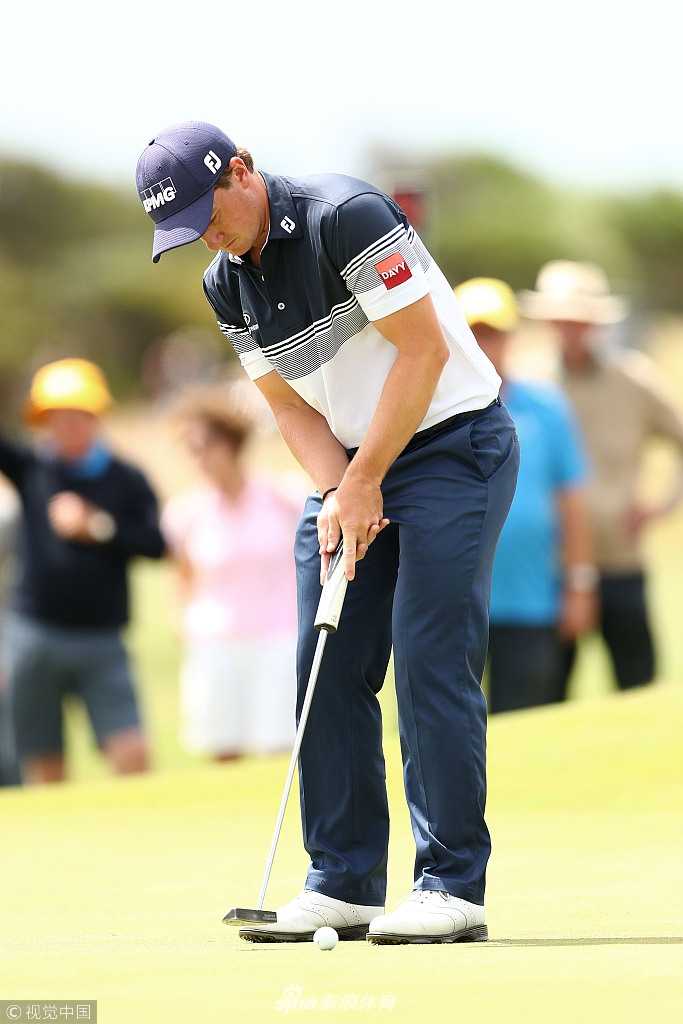 观众们聚集在沙丘上看台，海风吹拂彩旗，构成一幅动静相宜的观赛画卷