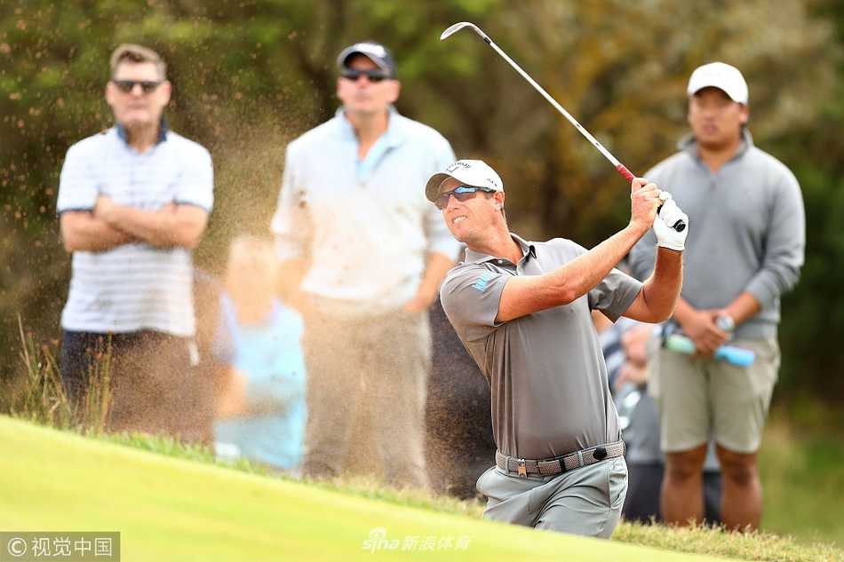 奥姆斯比站在发球台眺望远方，风鼓起他的衣衫，身影坚定如海岸雕塑