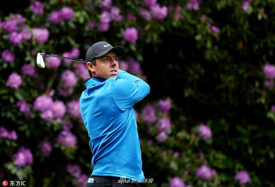 麦克罗伊在果岭边神情专注，进行一记精妙的切杆，小球划过一道优雅的弧线飞向旗杆