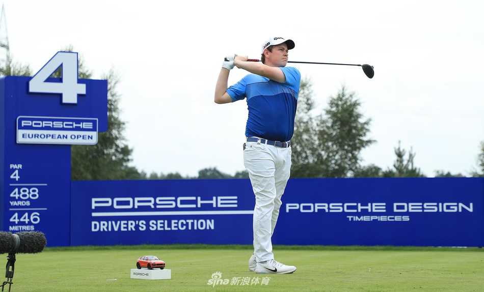 赛场观众聚集在果岭周围，屏息凝神观看球员挑战关键推杆