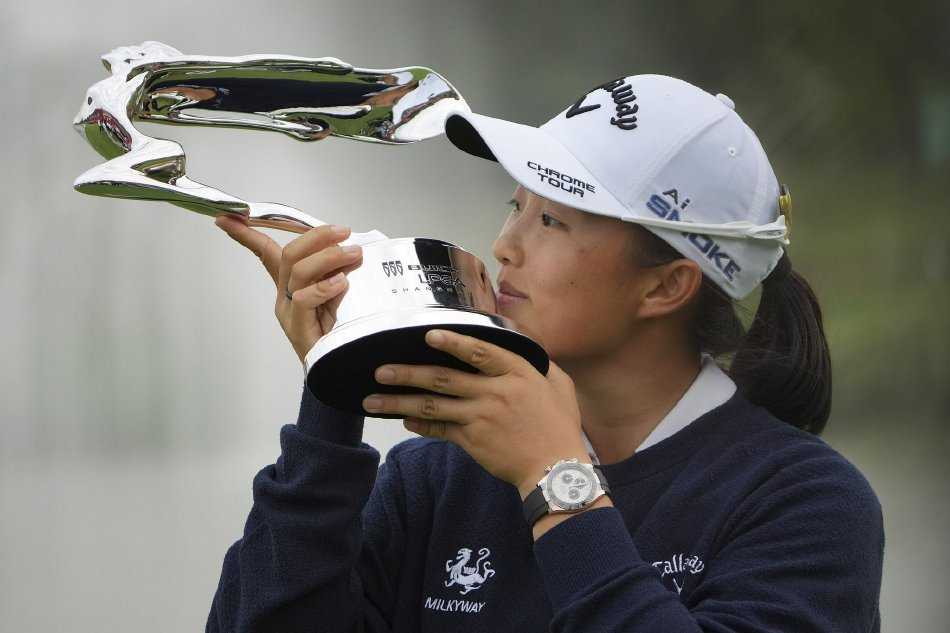 殷若宁在果岭边凝神观察推杆线路，她单膝跪地，神情专注，展现出顶级球员对每一杆的极致认真与精确计算。