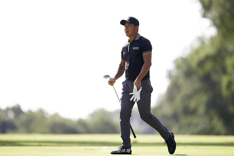 瓦尔德拉玛之战:卡特林坚守领先,凯梅尔紧追不舍,吴阿顺稳步前行 赛事观众在风景如画的瓦尔德拉玛球场边驻足观赛,阳光洒在松林与果岭上,构成了一幅高尔夫与自然完美融合的画卷。