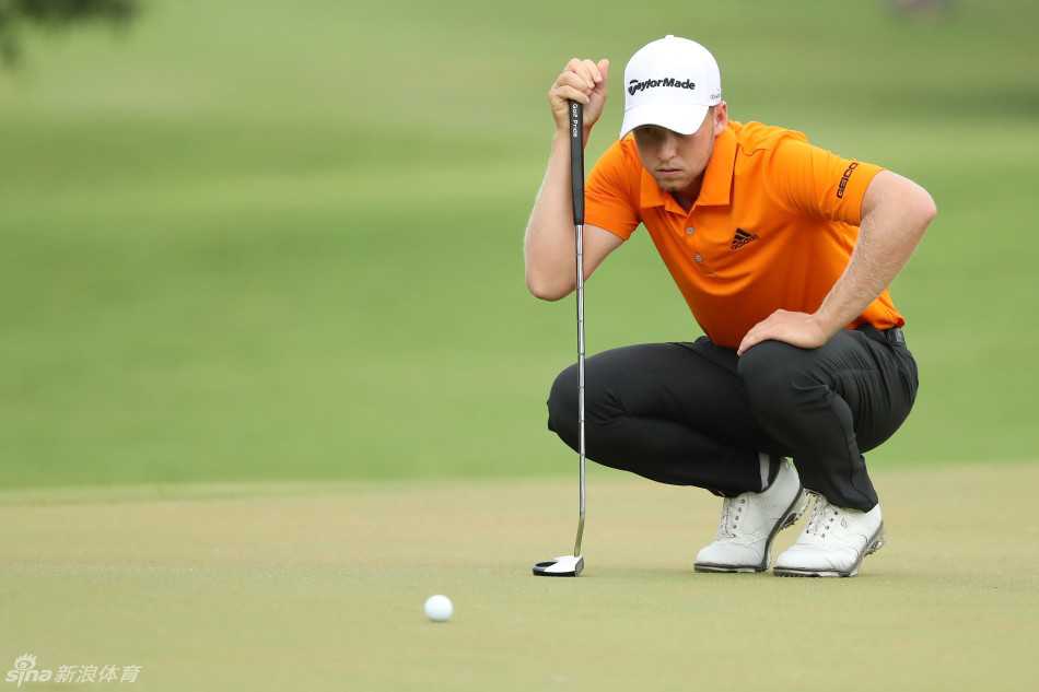 丹尼尔·伯格在果岭上俯身专注地研读推杆线路，指尖轻抚草叶，仿佛在聆听球场最细微的起伏。