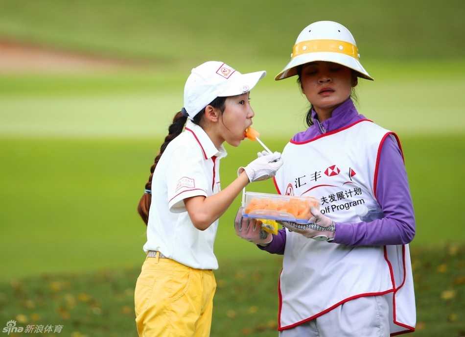 汇丰青少年以球育人赛场内外书写仁义礼智信 阳光洒在绿茵茵的果岭上,一位小球员正在弯腰仔细帮同伴寻找小白球,体现了互助的义精神