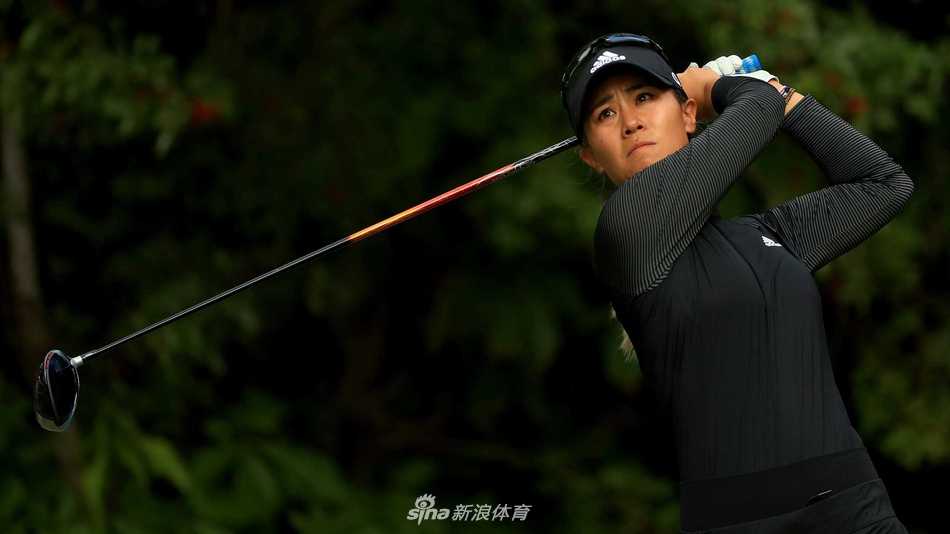 杰西卡·科达在果岭上弯腰专注地观察推杆线路，手指指向远方，正在与球童认真商讨战术。