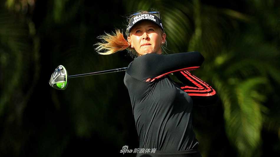 一位女球员在沙坑中救球，沙粒被击起，画面充满动感与力量，展现了比赛中应对困境的瞬间。