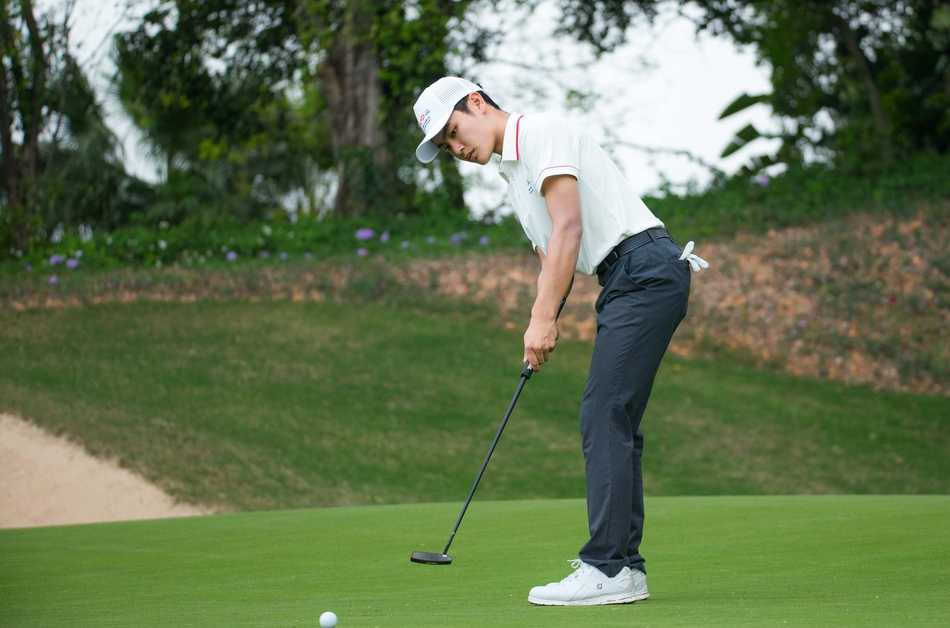 汇丰青少年高尔夫冠军赛清远站战幕拉开 吴荫轩安彤首日领跑男女A组 男子A组领先者吴荫轩在碧桂园假日半岛球会果岭上专注观察推杆线路,背景是葱郁的岭南园林景观。