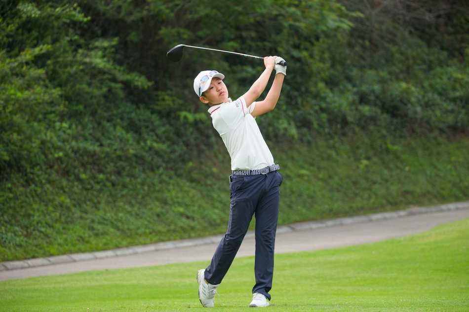 小选手凝神静气，在果岭上细致测量推杆线路与力度