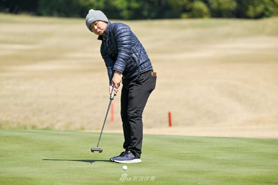 果岭上，球员屈膝细致查看推杆线路，手指轻抚草尖，眼神如鹰隼般捕捉着地形的细微起伏。