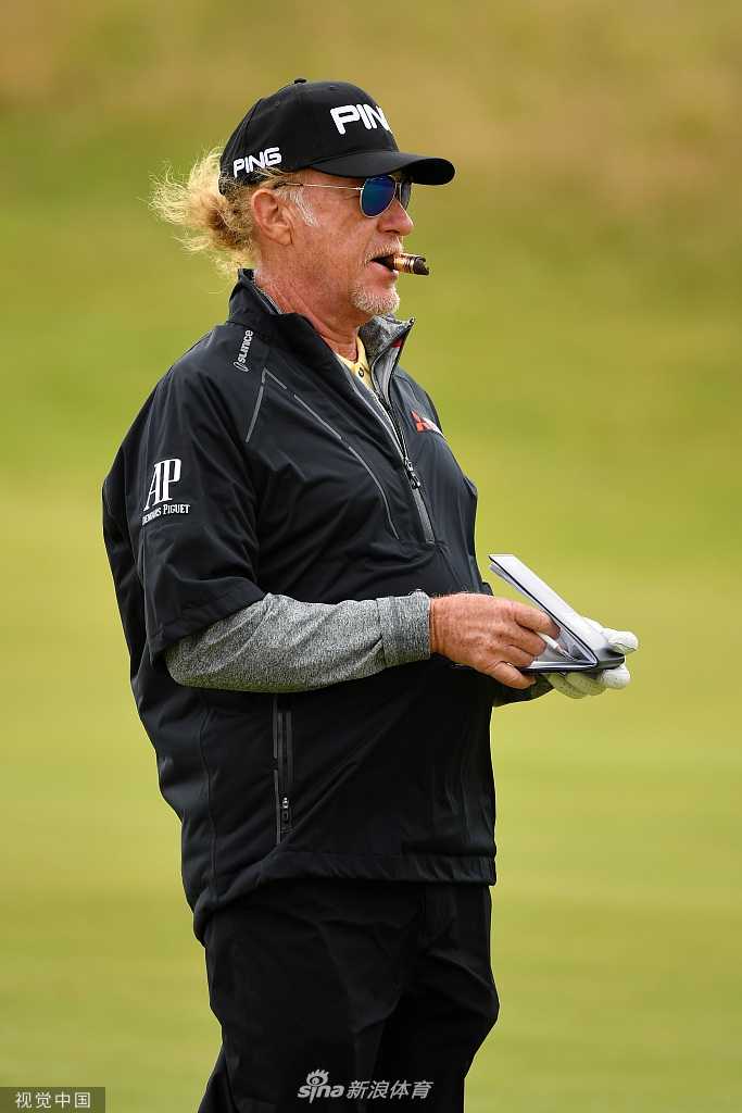 老虎伍兹在皇家波特拉什第18洞果岭上露出标志性微笑，与同组球员轻松交流，展现出大赛前的从容气度。