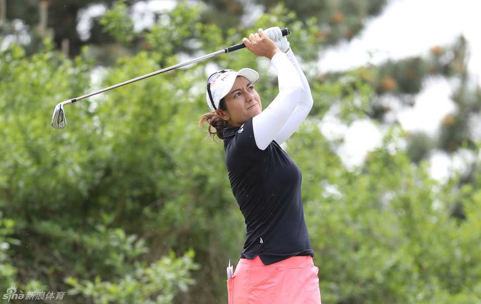 玛丽娜-亚力克斯全力挥杆瞬间，身体完美扭转，球杆在蓝天背景下划出银色弧线