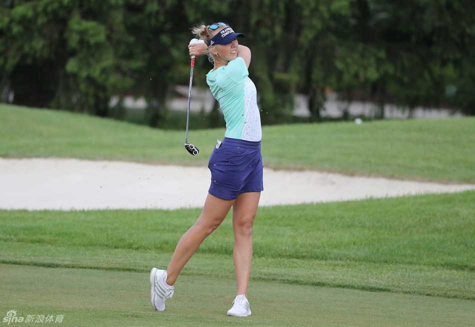 杰西卡-科达单膝跪地阅读果岭，手指轻触草叶评估坡度与速度