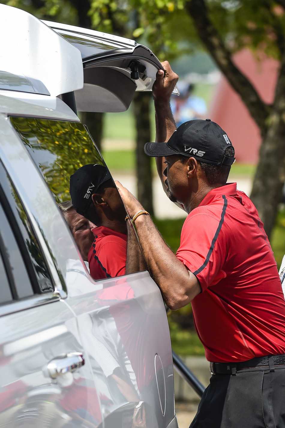 伍兹身体后仰失去平衡，即将跌入沙坑的瞬间，手臂在空中试图寻找支撑