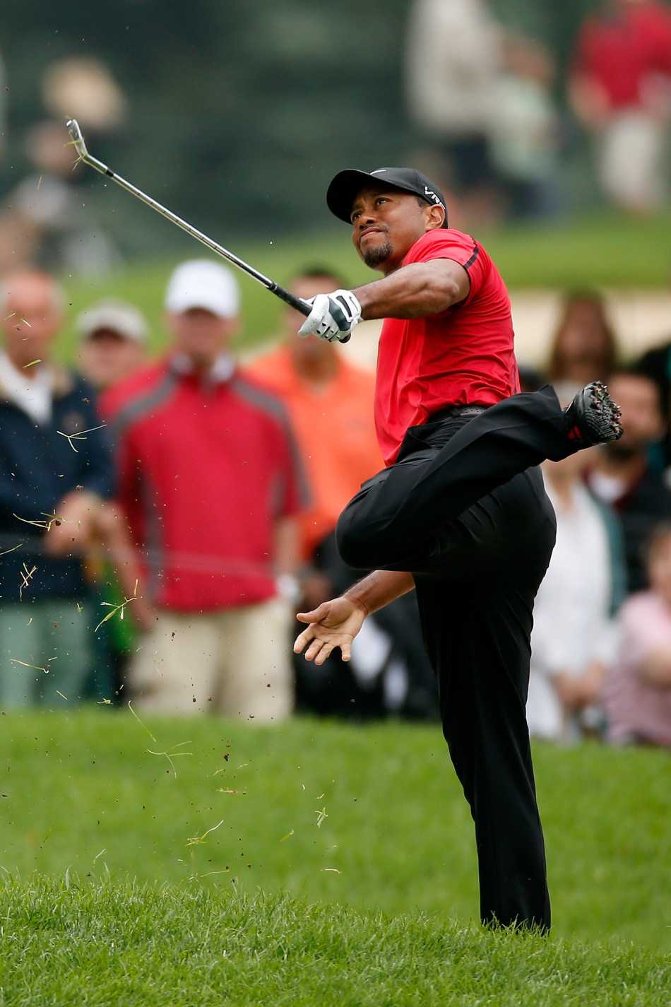 伍兹双手撑在车尾，背部不敢发力，低头忍受着腰部痉挛的剧痛，姿态无助