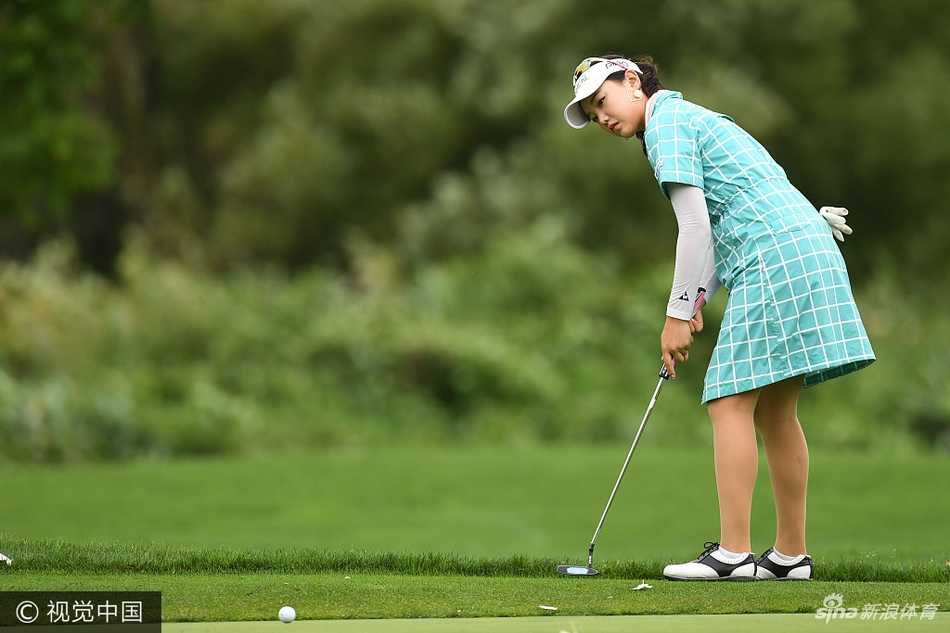 申智爱果岭边观察线路，神态专注，为下一杆推击做精心准备。