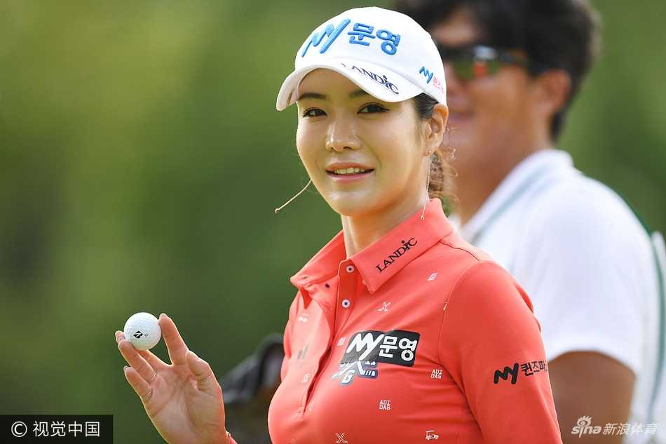 石昱婷侧身站立，目光坚定地望向远方果岭，展现对比赛的思考与决心。