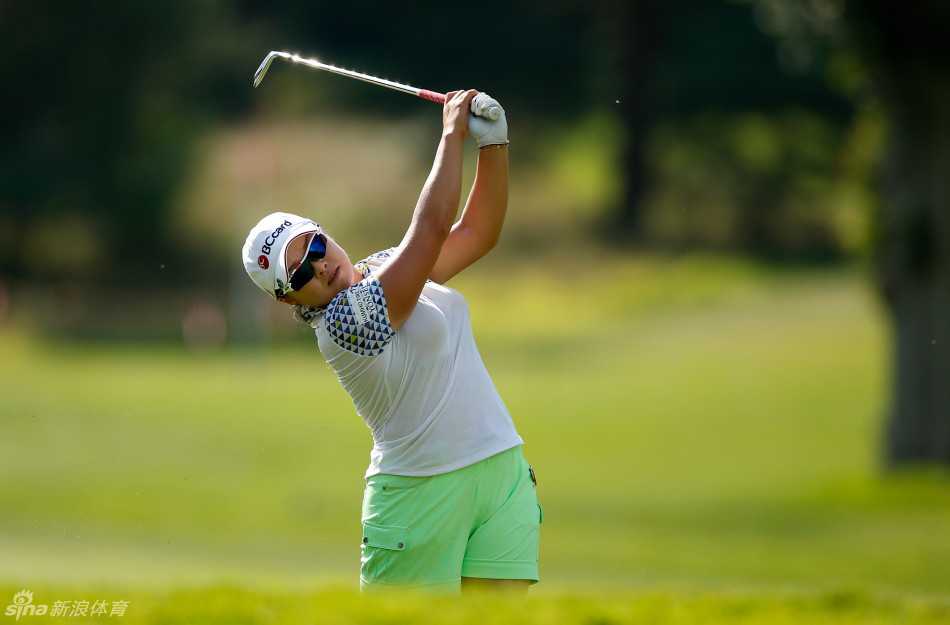 莱克西-汤普森手握高尔夫小球，神情轻松而自信，阳光洒在她的金发上，仿佛一切尽在掌握。