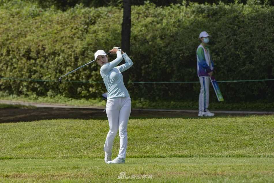 秦岭山下挥杆逐梦 全运赛场群英荟萃 两位球员在球道上并肩行走交流,展现了赛场上的友谊与体育精神。