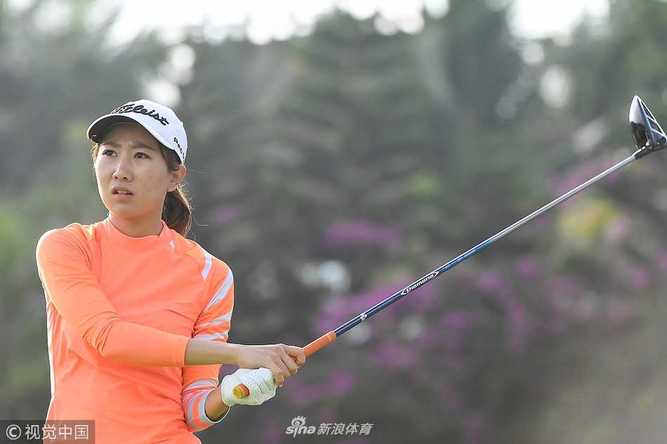 球手在果岭边仔细研判推杆路线，翠绿的果岭与远处的沙坑构成了一幅充满策略思考的宁静画面。