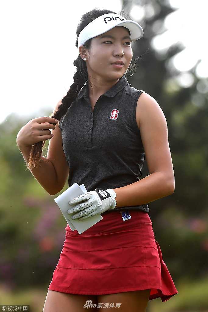 一位球手侧身站立，目光坚定地望向前方球道，专注的神情与身后开阔的球场融为一体。