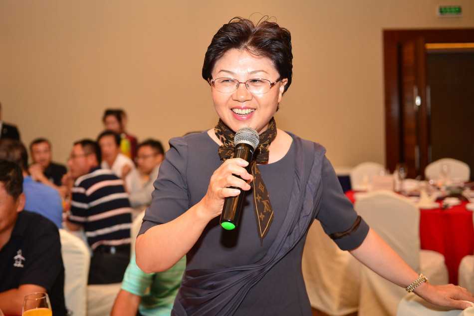 第七届新浪高尔夫博友欢聚晚宴纪实 博友老胡与VOODOO并肩站立,手持晚宴纪念品面向镜头微笑合影,背景是宴会厅璀璨的灯光。