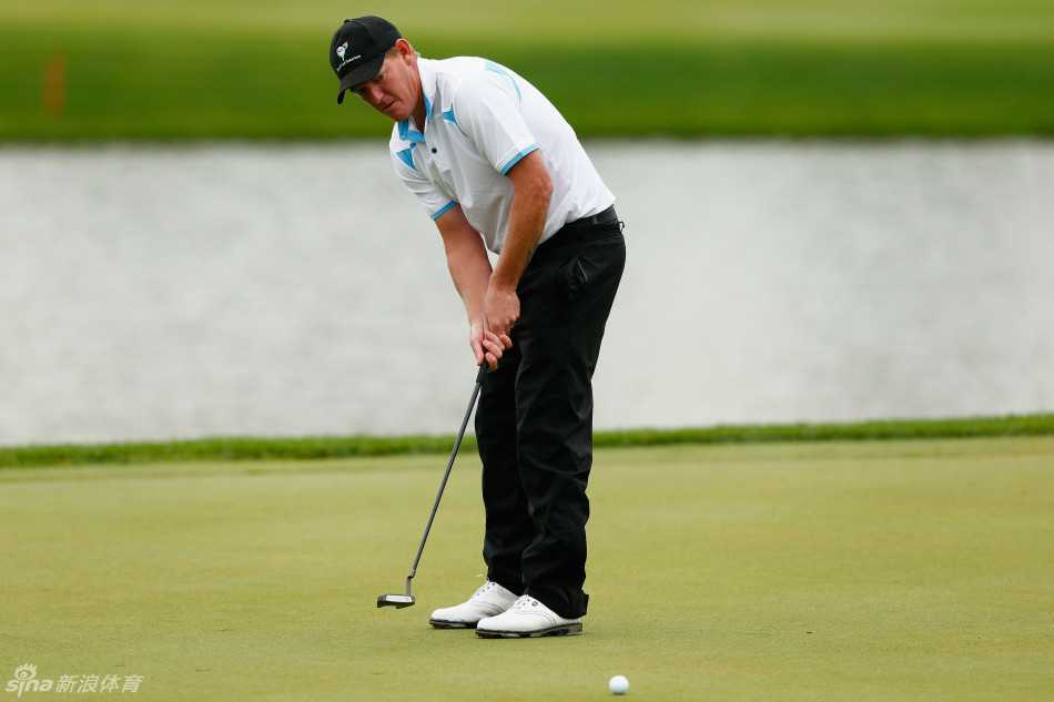 绿茵之上:挥杆间的力与美,果岭上的智与静 球员高恩特在果岭上单膝跪地,与球童一同凝视推杆线路,专注商讨战术