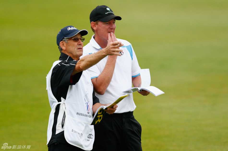 绿茵之上:挥杆间的力与美,果岭上的智与静 球员高恩特在果岭边细致擦拭高尔夫球,为下一杆推杆做准备