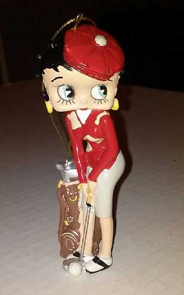 毛绒麋鹿玩偶头戴圣诞帽，用两只前蹄握着一根迷你高尔夫球杆，摆出憨态可掬的挥杆动作，节日气氛拉满。