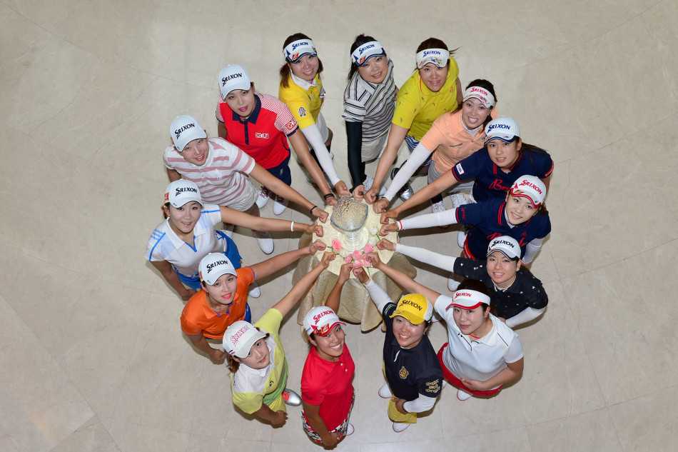 卫冕冠军刘钰被众球员围绕在中央，手持奖杯开怀大笑，身旁的日韩球友纷纷竖起大拇指