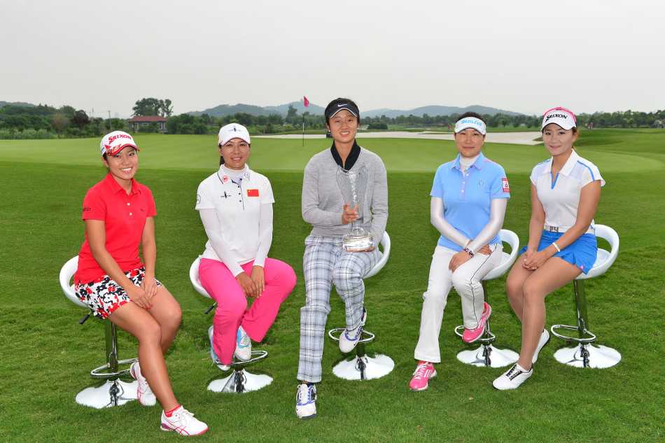 阳光洒在第18洞果岭上，中日韩球员并肩而立，笑容灿烂如花，身后是起伏的绿坡与湛蓝天空