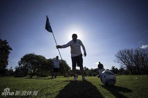 绿茵场上的智慧角逐:足球高尔夫融合运动的魅力 一位球员在阿根廷蒂格雷的足球高尔夫比赛中,正专注地瞄准远处的球洞,准备用一记精准的推踢将球送入果岭上的大洞。