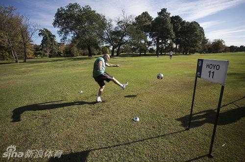 绿茵场上的智慧角逐:足球高尔夫融合运动的魅力 在广阔的球道上,一名球员正在评估足球与远处球洞之间的复杂路线,思考如何避开中间的沙坑障碍。