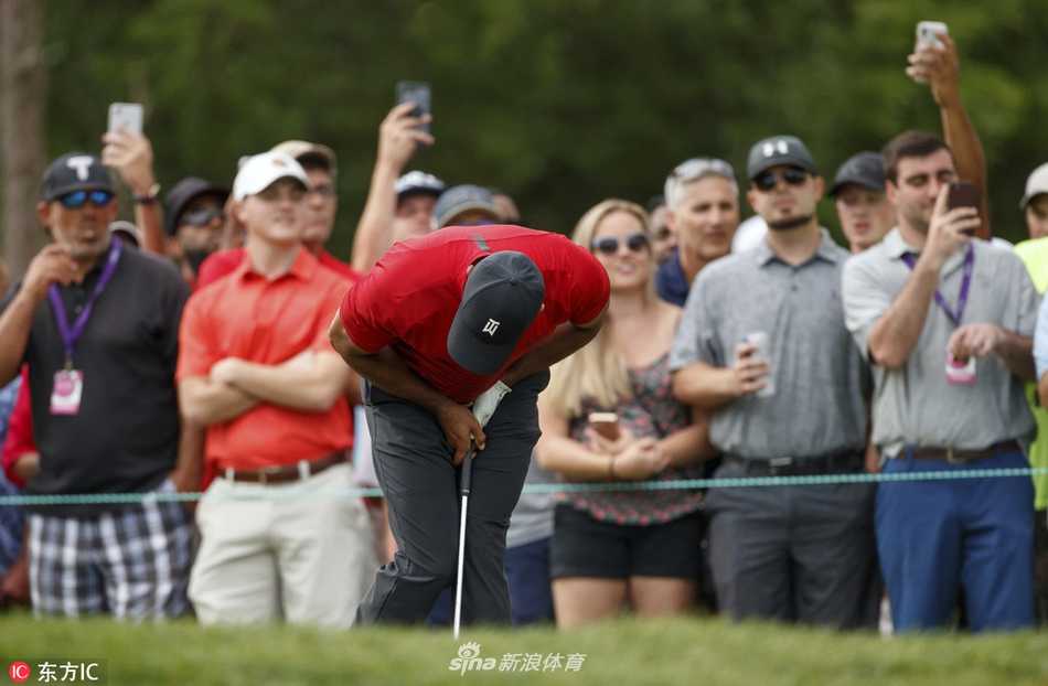 伍兹站在第18洞果岭，凝视着决定命运的最后一次推杆，红色上衣与周遭的绿意形成强烈对比，空气中凝聚着亿万人的期待。