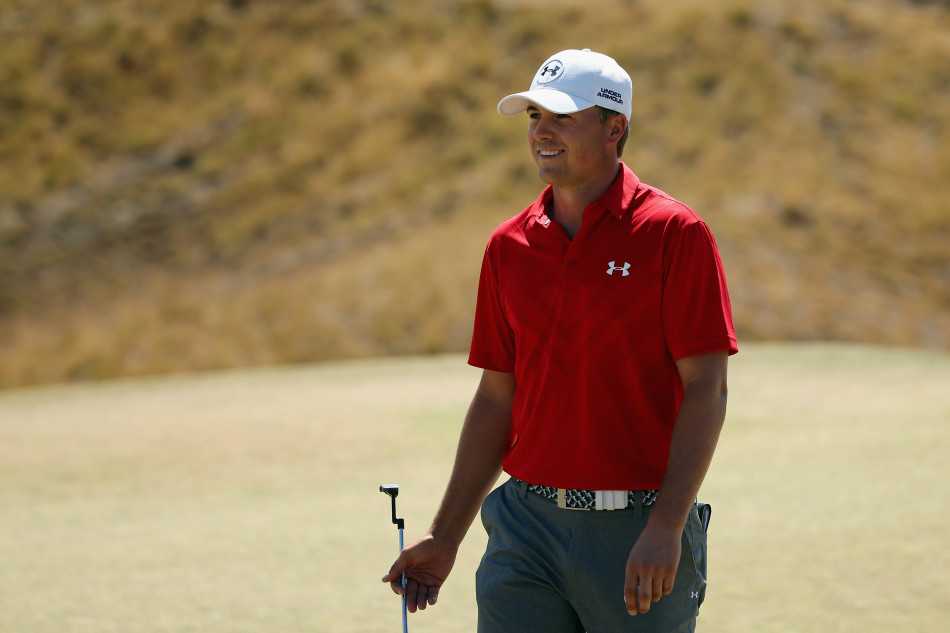 乔丹·斯皮思在第18洞果岭上，凝神研究决定冠军归属的关键一推，眼神专注如炬。