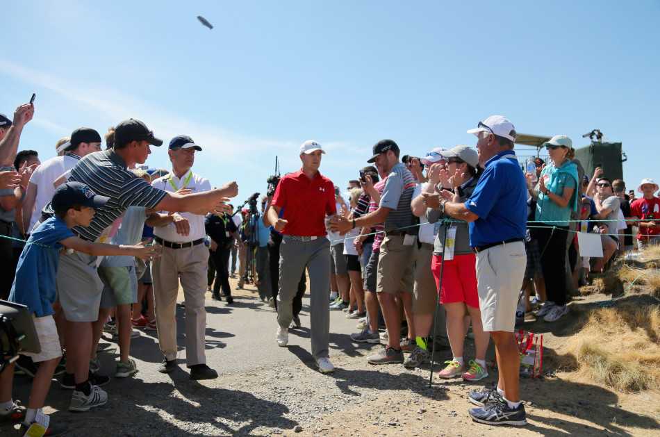 决赛轮关键洞，达斯汀·约翰逊开球后，白色小球在空中划出弧线，背景是紧张的观众与裁判。